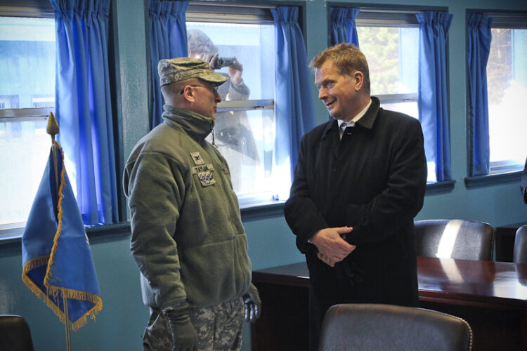  President Niinistö viewing the negotiation room, which is located squarely on the border between South and North Korea. North Korean soldiers observe from the other side of the window. Copyright © Office of the President of the Republic of Finland