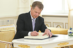 Presidentti Niinistö kirjoittaa nimensä presidentinlinnan vieraskirjaan. Copyright © Tasavallan presidentin kanslia 