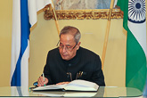  Presidentti Mukherjee allekirjoittaa vieraskirjan. Copyright © Tasavallan presidentin kanslia 
