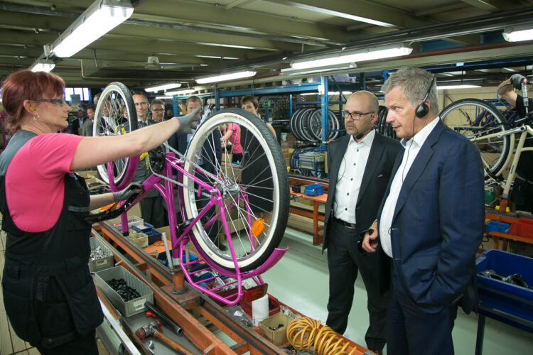 Efter besöket i skolan besökte president Niinistö cykelfabriken Helkama Velox. Verkställande direktören Jari Elamo (i mitten) förevisar monteringen av en Jopo-cykel, en modell som i år fyller 50 år. Copyright © Republikens presidents kansli