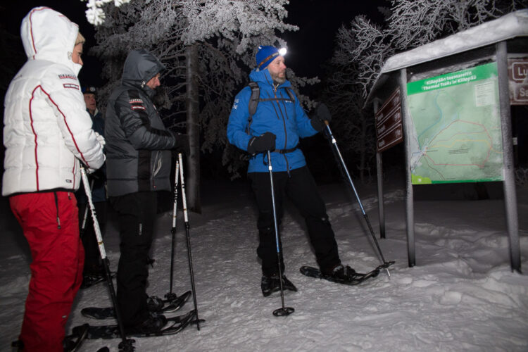  Presidentparet prövade på snöskovandring i Kiilopää fjällcenter. Huvudguiden Pekka Kulha berättar om rutten. Bild: Matti Porre/Republikens presidents kansli
