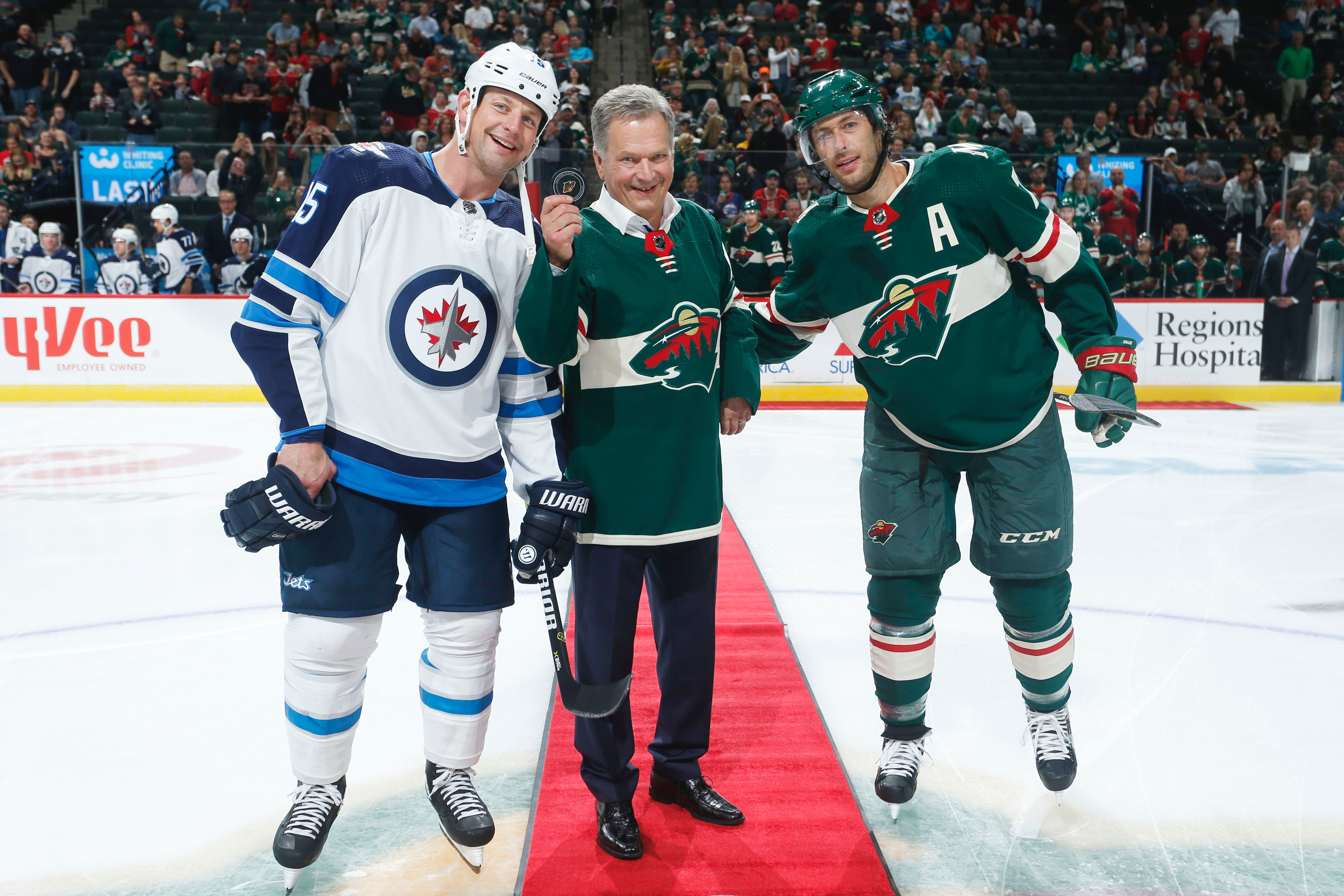 Finnish President Sauli Niinisto poses for a photo with Matt Hendricks #15 of the Winnipeg Jets and Matt Cullen #7 of the Minnesota Wild after the ceremonial puck drop prior to the game at Xcel Energy Center.  kuva: Courtesy of Minnesota Wild/Bruce Kluckhohn