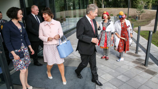 Uuden lastensairaalan tukisäätiön puheenjohtaja Anne Berner saattaa rouva Jenni Haukion ja presidentti Sauli Niinistön avajaistilaisuudesta. Sairaalaklovnit tervehtivät vieraita. Kuva: Matti Porre/Tasavallan presidentin kanslia