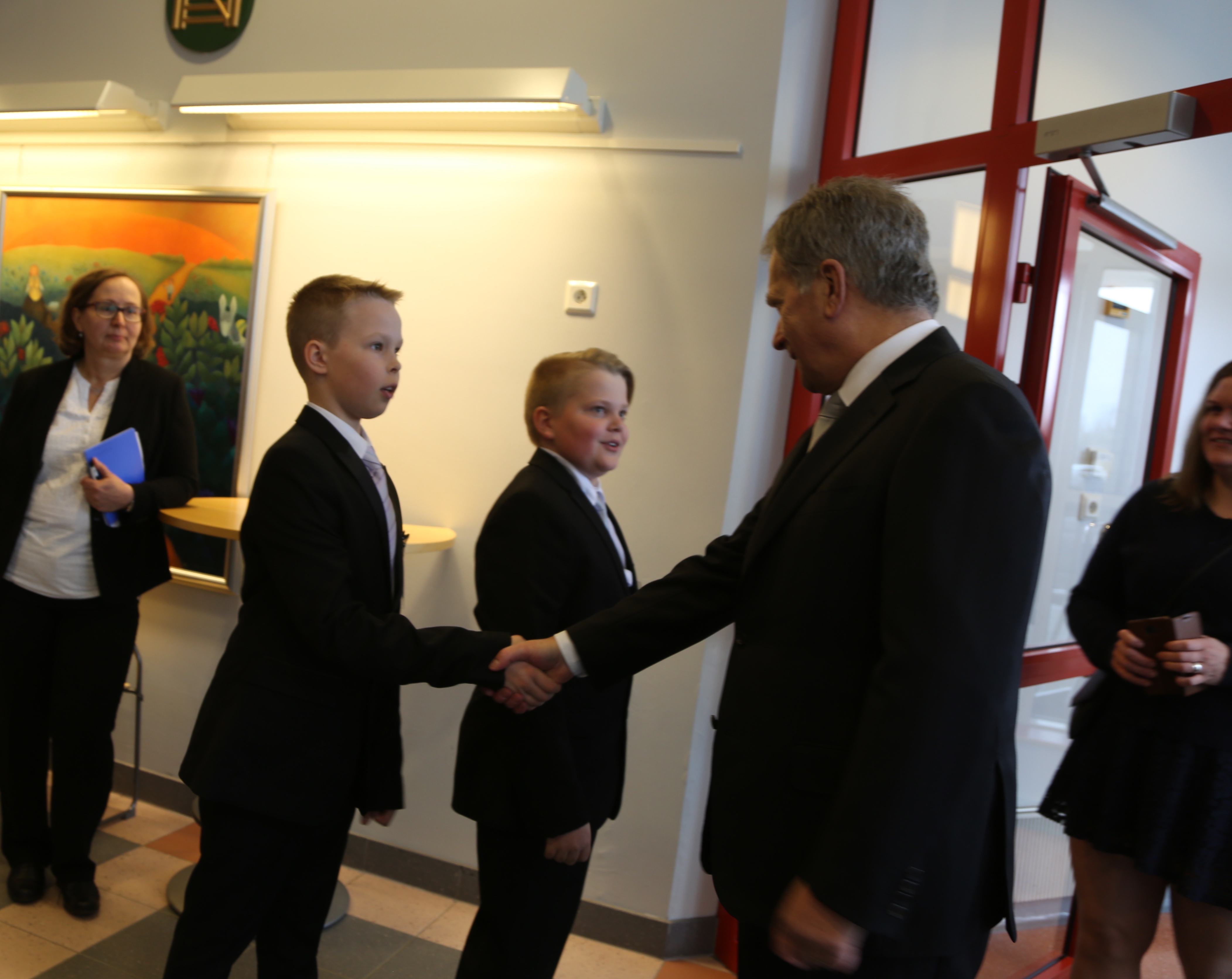 Kallion suvun Leevi Saalasti ja Eetu Isokoski vastaanottivat vieraat Sovinnonpuheen juhlaan Kyösti Kallion koululle.